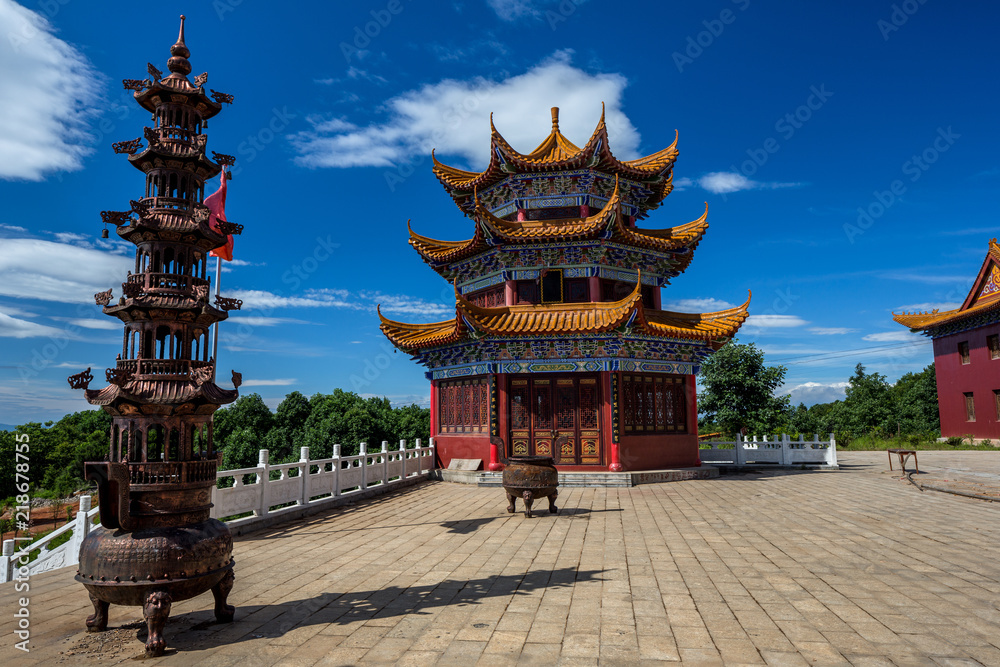 Fototapeta premium Chinese pagoda, religious temple architecture near to the city of Jingzhou, Hunan Province China. Feishanzhai, colorful Chinese architecture with bright red, and orange and blue painted colors.
