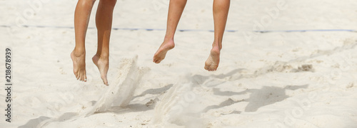 Close-up of feet and legs of a male beach volleyball player photo