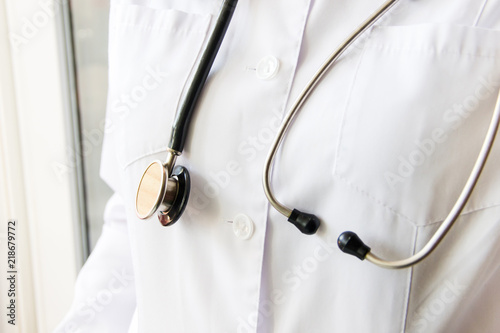 Medical concept of female doctor in white coat with phonendoscope, no face, close up. Woman hospital worker