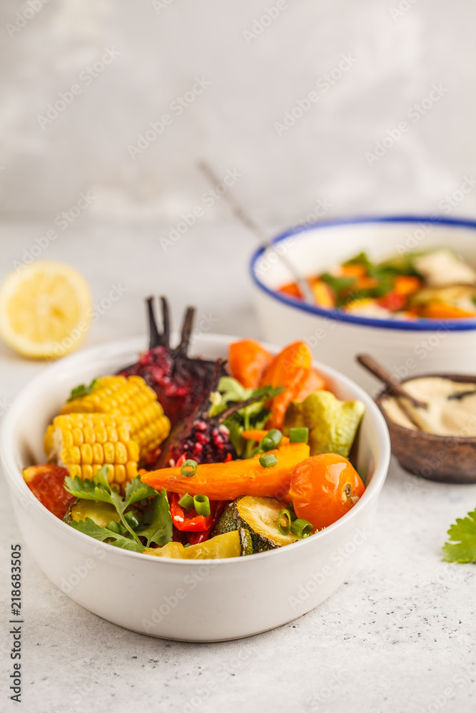 Salad with baked vegetables with tahini in white plate, white background. Clean eating concept. Salad with baked vegetables with tahini in white plate, white background. Clean eating concept.