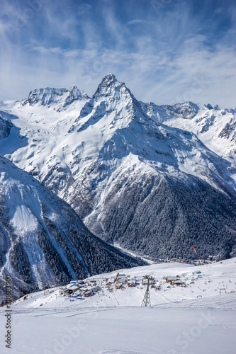 Mt. Belalakaya and ski lift, cafe and restaurants on a ski slope in winter sunny day. Dombai ski resort, Karachai-Cherkess, Western Caucasus, Russia.