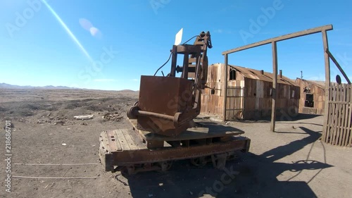 Abandoned Humberstone and Santa Laura saltpeter works factory, near Iquique, northern Chile, South America. Camera moves around old rusty historic lifting object.
