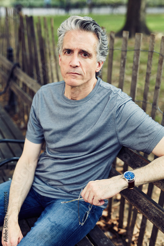 Grey Haired Man Sits on Park Bench