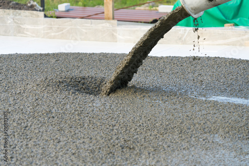 Pouring concrete from a concrete mixer. The work of people pouring concrete.