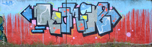 Full and acomplished graffiti artwork. The old wall decorated with paint stai...