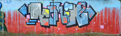 Full and acomplished graffiti artwork. The old wall decorated with paint stai...