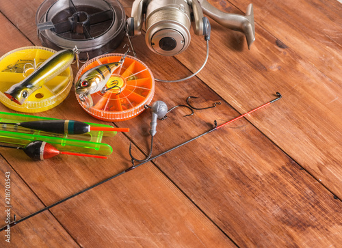 Floats, spinning and boxes with baits on a wooden background