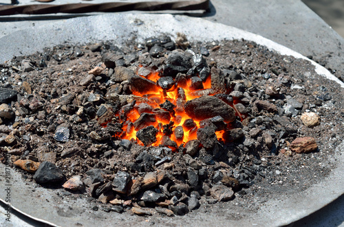 Red, hot coals burn in the forge horn. Equipment for forging metal.