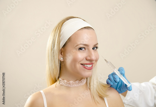 Beautiful young woman smiling receiving botulinum toxin treatment 