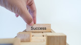 success word written on wood block with hand on white background