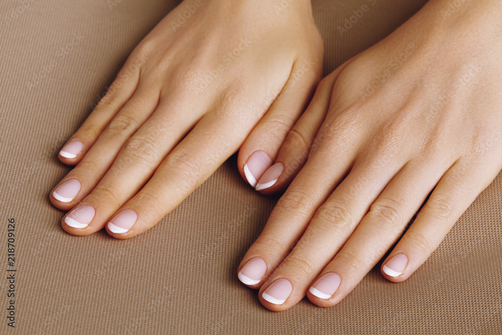 Young Female Palm. Beautiful Glamour Manicure. French Style. Nail polish. Care about Hands and Nails, clean Skin