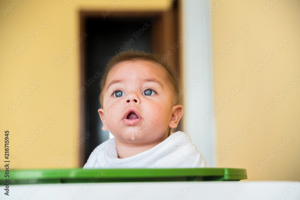 Baby boy playing inside the plastic basin - with cloth diaper on the neck - drooling