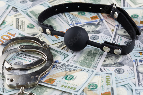 Black gag and handcuffs on american dollars banknotes