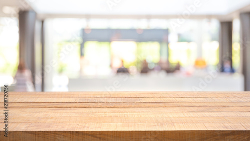 Empty wooden bar counter with Abstract blurred image of people waiting for room registration at reception counter or front desk.