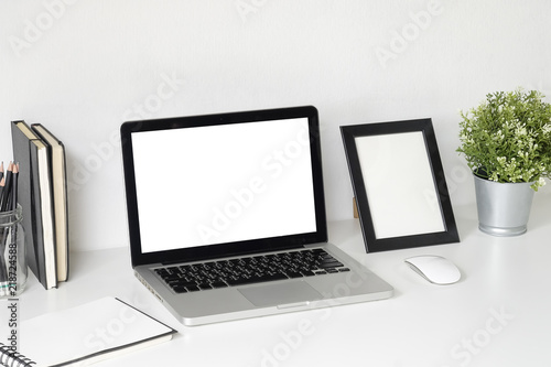 Workspace with Mockup laptop computer on white table with office supplies.