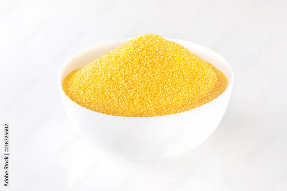 Closeup image of bowl with raw polenta corn isolated at white background. Closeup image of bowl with raw polenta corn isolated at white background.