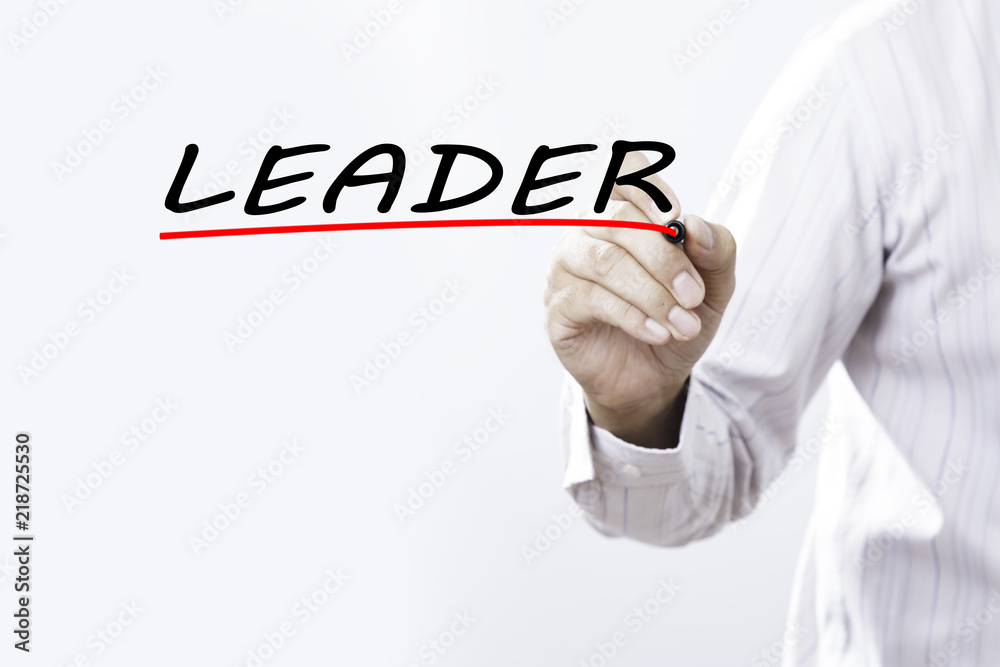 Businessman hand writing leader with red marker on transparent wipe board, business concept Businessman hand writing leader with red marker on transparent wipe board, business concept