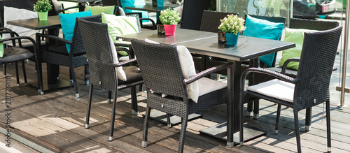 Cafe terrace in small European city. Beautiful terrace or balcony with small table, chair and flowers.