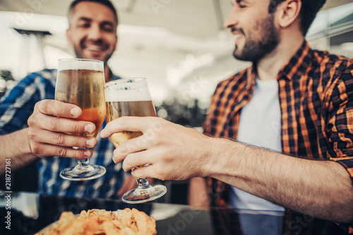 Drink to that. Close up of male hands with alcohol drinks. Smiling gentlemen on blurred background
