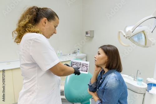 Dentist showing a patient her teeth x-ray. Healthcare  medical and dentistry concept