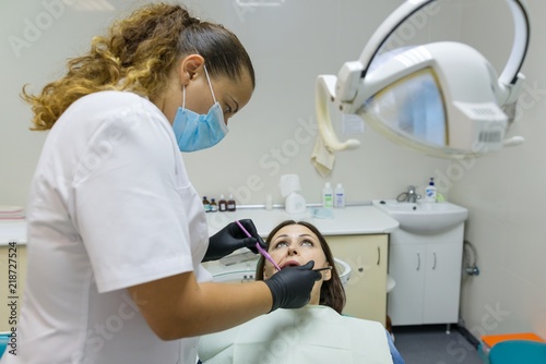 Adult female dentist treating patient woman teeth. Medicine  dentistry and healthcare concept
