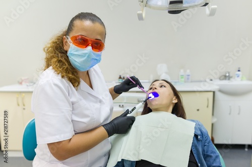 Adult female dentist treating patient woman teeth. Medicine  dentistry and healthcare concept