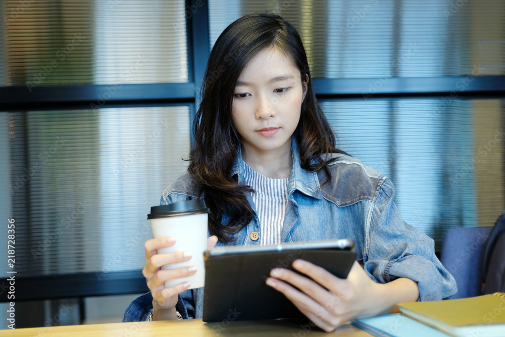 Young asian woman holding a coffee cup and digital tablet sitting in room, lifestyle, working from home, adult online education concept