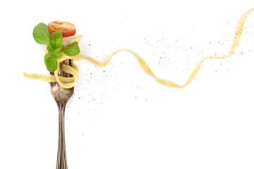 Italian pasta. Overhead photo of vintage fork with pappardelle, basil, cheese, and tomato, on white background