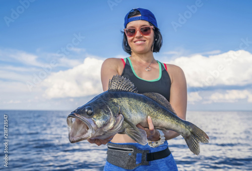 Happy fisher woman with zander fish trophy at the boat