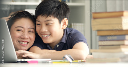 Cute asian mother helping your son doing your homework .