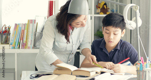 Cute asian mother helping your son doing your homework .