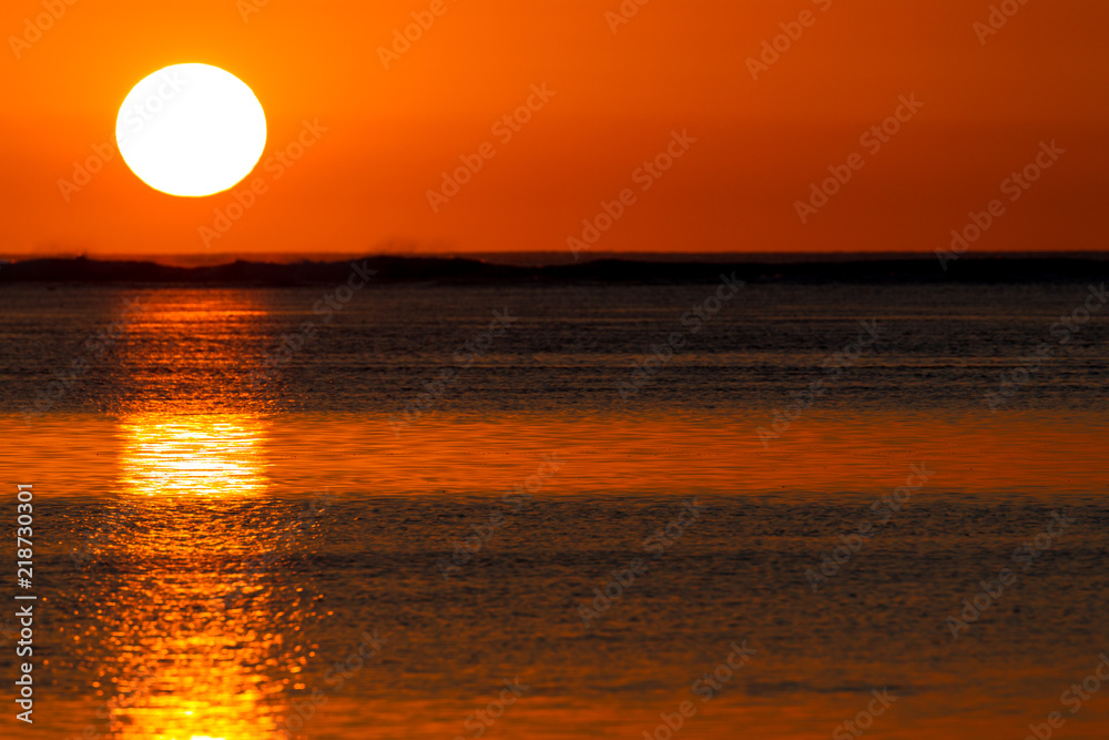 Die untergehende Sonne spiegelt sich im ruhigen Wasser der Lagune vor Le Morne, Mauritius, Afrika.