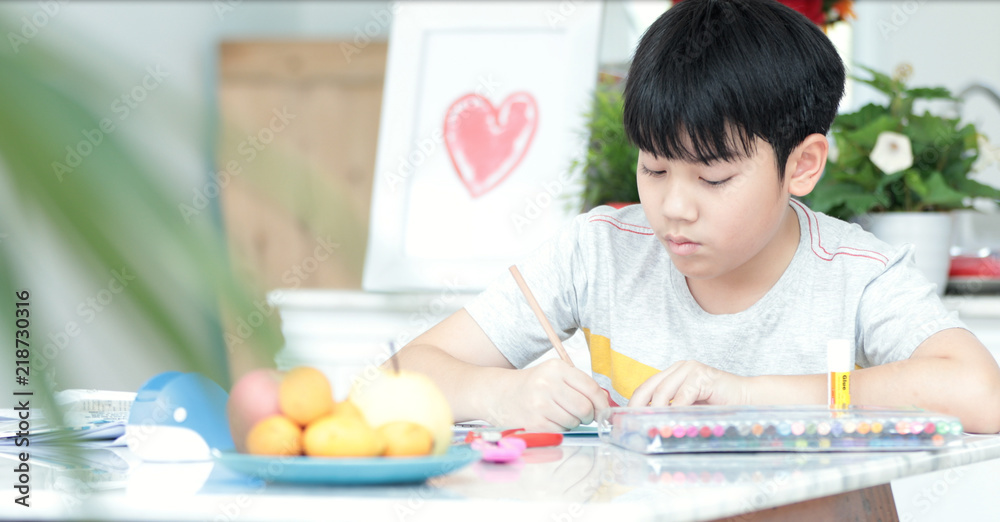 Asian boy hand holding pencil and writing your homework . Asian boy hand holding pencil and writing your homework .