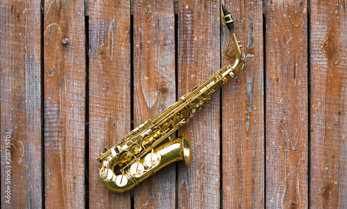 Beautiful golden saxophone on wooden background