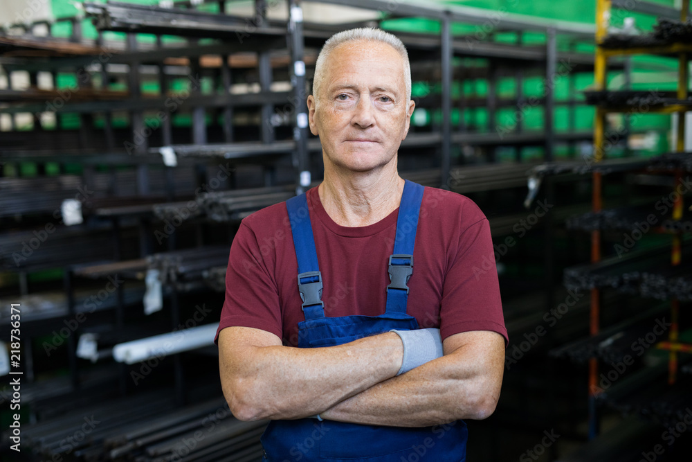 Portrait of mature serious foreman standing with arms crossed on the production Portrait of mature serious foreman standing with arms crossed on the production