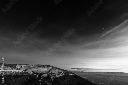 A view of some mountains top, beneath a beautiful sky at sunset