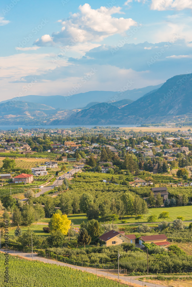 City of Penticton view with orchards and vineyards and Skaha Lake and mountains in distance in summer
