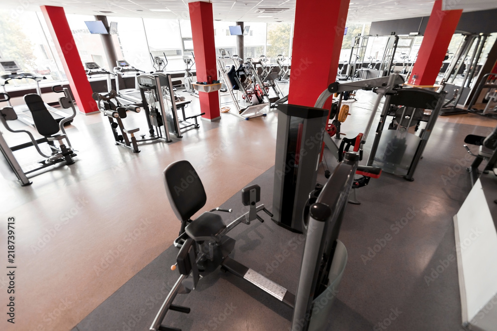 Gym interior with red columns including modern fitness stations. concept of sport and healthy lifestyle