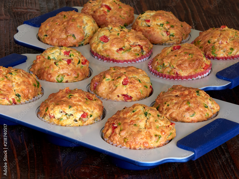Fototapeta premium Two trays of savory muffins with cheddar, spinach and red peppers
