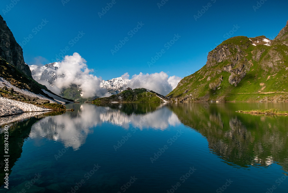 Swiss alps water reflection in Lac de Louvie - mountain lake above Val de Bagnes valley, Switzerland.