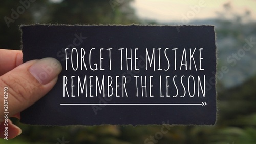 Motivational and inspirational quote - ‘Forget the mistake, remember the lesson’ written on a black paper. Vintage styled background. photo