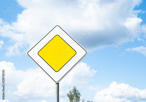 Road sign main road traffic priority against blue sky background