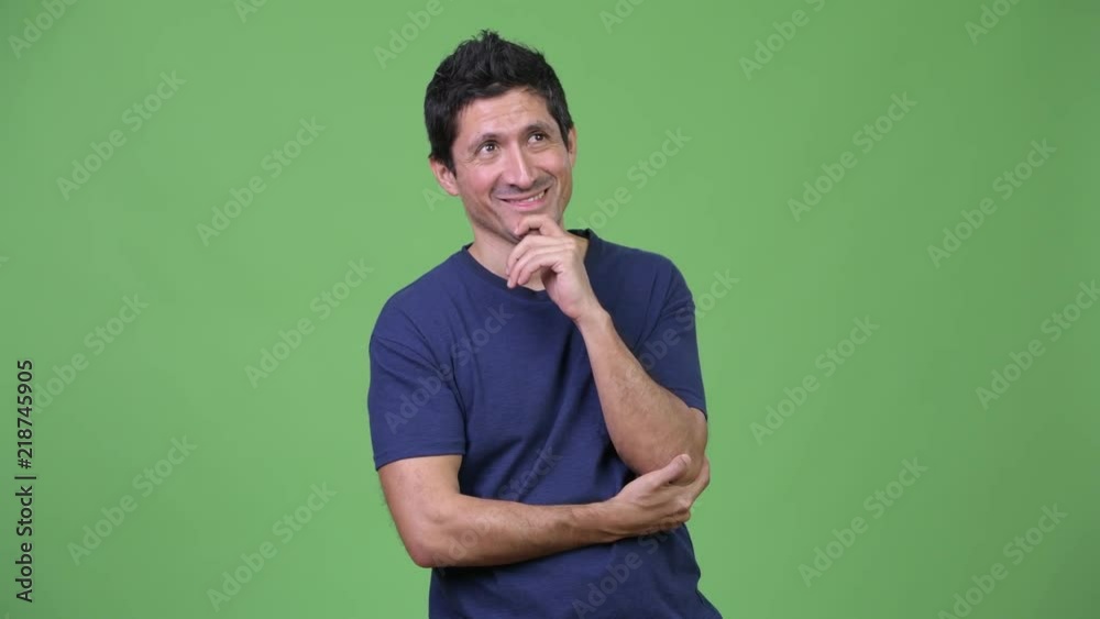 Hispanic man thinking against green background Hispanic man thinking against green background