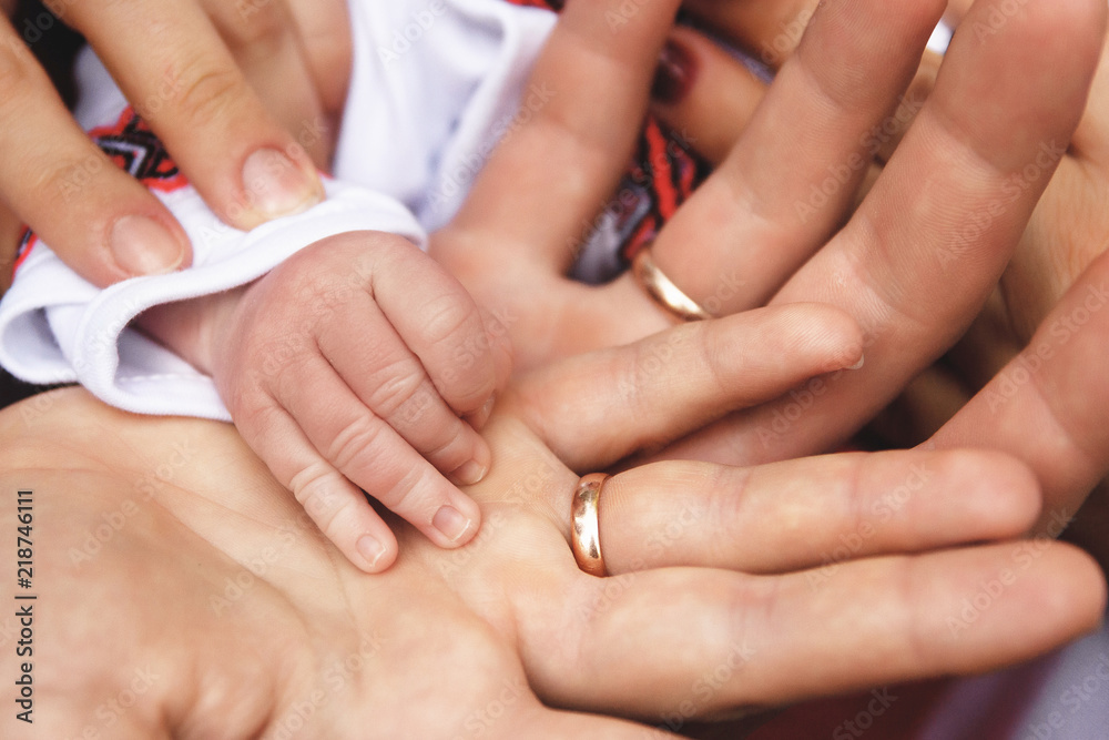 hands of parents and their baby. parents are holding their baby's hand hands of parents and their baby. parents are holding their baby's hand