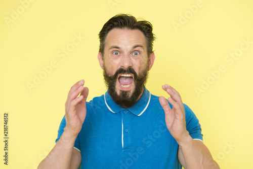 Overwhelmed with emotions. Handsome shouting mature man screaming standing against yellow background. Man bearded irritated annoyed can not keep calm anymore. Stop annoying him. Stressful adult life © be free