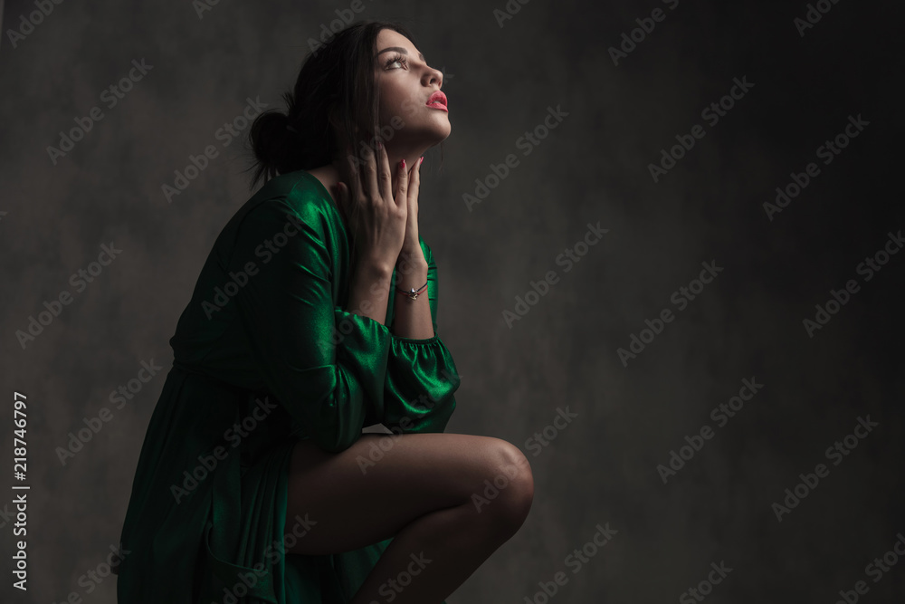 sensual woman in green ballroom dress touching her neck