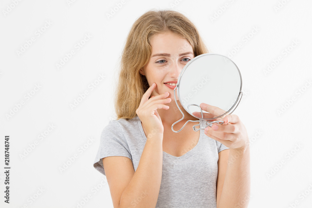 Young caucasian blonde woman looking wrinkles on face in mirror isolated on white background. Skin care and makeup concept. Copy space Young caucasian blonde woman looking wrinkles on face in mirror isolated on white background. Skin care and makeup concept. Copy space