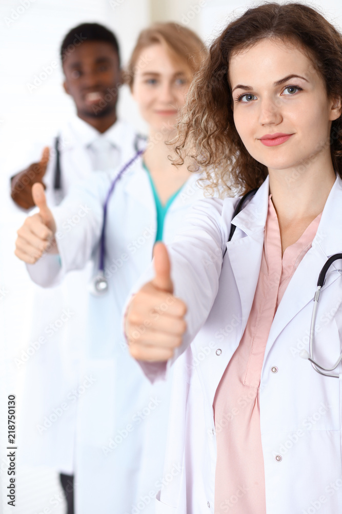 Medical team of confident doctors showing Ok sign with thumbs up. Medicine and health care, insurance concept Medical team of confident doctors showing Ok sign with thumbs up. Medicine and health care, insurance concept