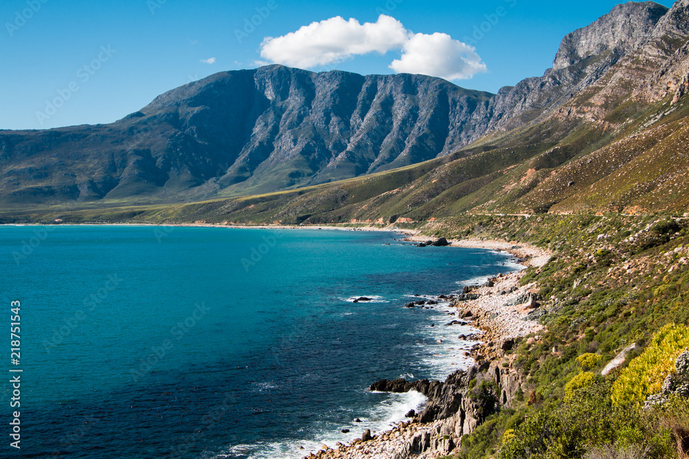 Landscape of the shoreline with the sea and mountains, blue sky and clouds in Cape Town South Africa.