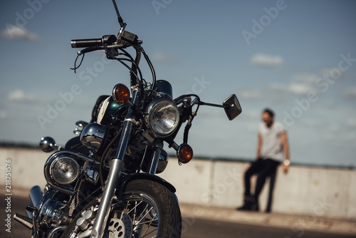 selective focus of classical chopper motorbike and man on background